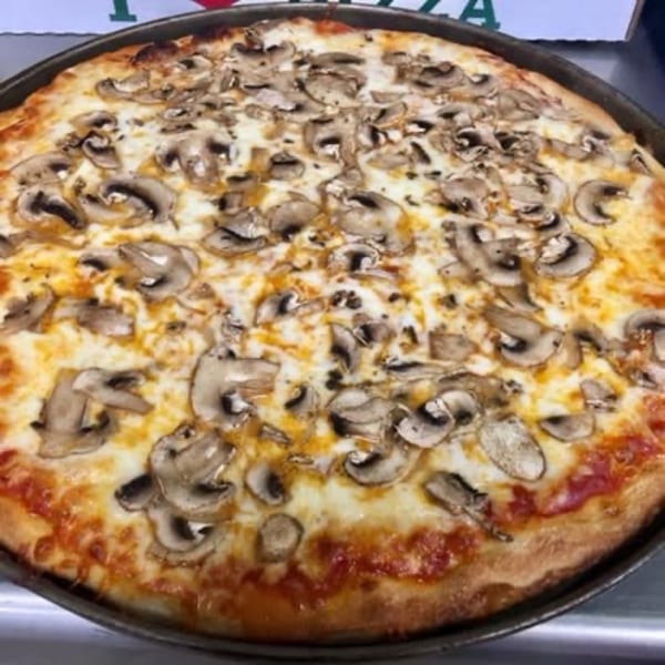 A freshly baked mushroom pizza from Pizza Village IV, with melted cheese and a golden crust.