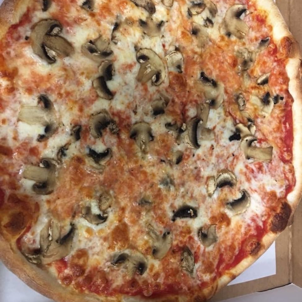 Close-up of a freshly baked mushroom pizza from Pizza Village IV, with melted cheese and tomato sauce.