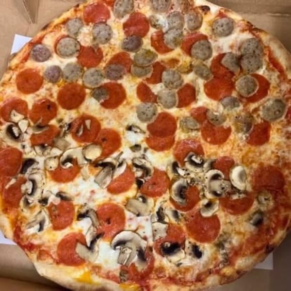 A large Pizza Village IV pizza with pepperoni, sausage, and mushrooms in a box.