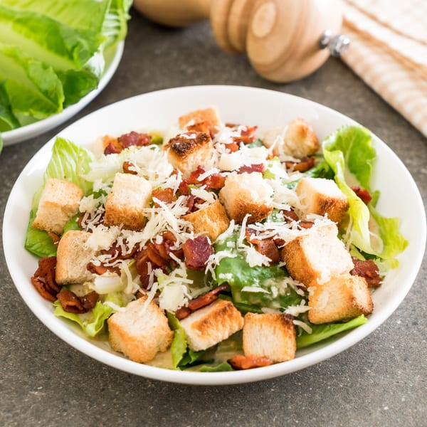 Caesar salad with crisp romaine lettuce, crunchy croutons, bacon bits, and shredded Parmesan cheese.