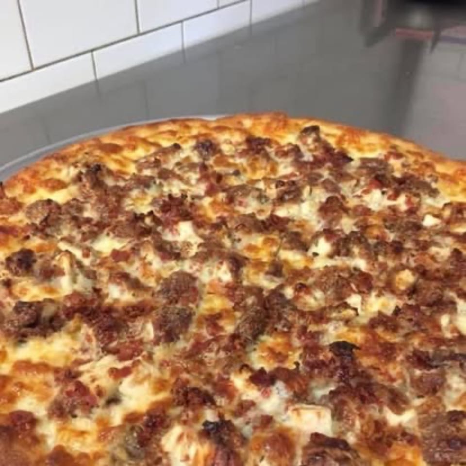 A close-up of a freshly baked Pizza Village IV pizza with sausage and cheese.